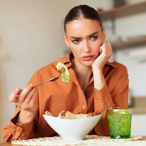 Frau isst Salat hat aber keinen Appetit
