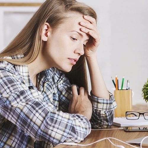 Frau am Schreibtisch mit Konzentrationsproblemen