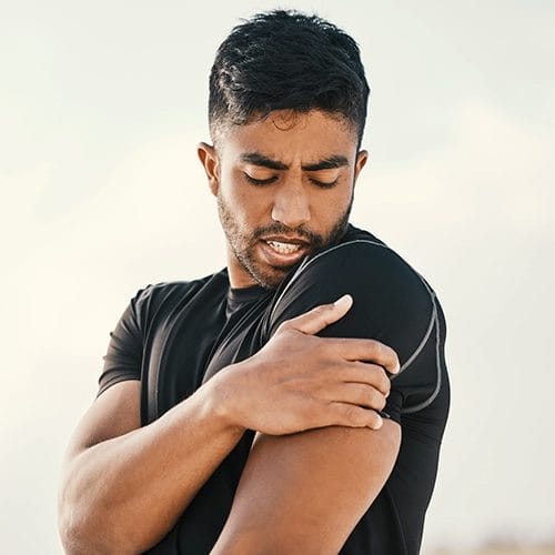 Mann mit Muskelverspannungen am Arm nach dem Sport