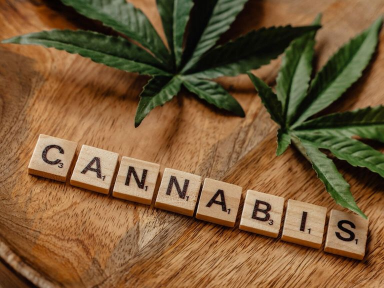 Cannabisblätter auf Holzteller mit Beschriftung