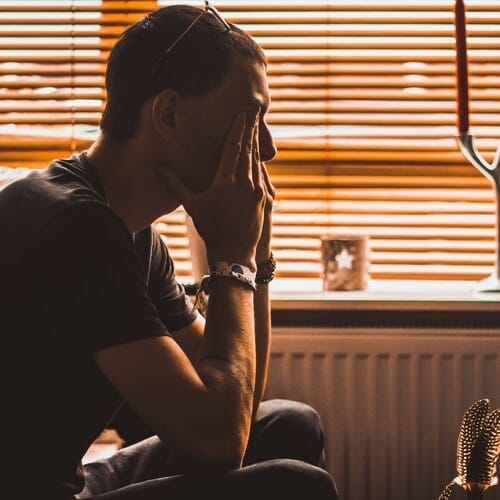 Mann reibt sich vor Müdigkeit die Augen.